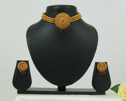 Gold necklace and earrings set on a black mannequin bust